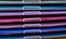 Stacks of colored paper in various shades of pink, purple and turquoise with blue