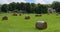 Stacks of dry hay on a green farmer`s field in an Irish village on a sunny summer day. Hay rolls. video