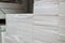 Stacks of expanded polystyrene in packaging at a building materials warehouse in a store. The insulation lies on metal racks in