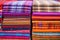 stacks of handwoven rugs in vibrant colors