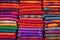 stacks of handwoven rugs in vibrant colors