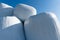 Stacks of hay bales wrapped in white plastic under a blue sky