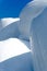 Stacks of hay bales wrapped in white plastic under a blue sky