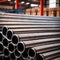 Stacks of metal pipes, construction components for industry, in storage in warehouse