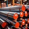 Stacks of metal pipes, construction components for industry, in storage in warehouse