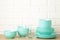 Stacks of mint ceramic dishware on light background