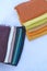 Stacks of multi-coloured fabrics or cloth or scarves or hijabs on a white background. Product photography or Textile industry