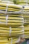 stacks of rolls yellow pvc plastic pipe on the counter in the store. Sale Hoses in the garden of various manufacturers, on shelves