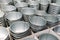 Stacks of silver tin buckets in white corrugated boxes.