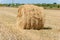 stacks of straw on sloping wheat field