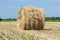 stacks of straw on sloping wheat field