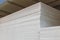 Stacks of thick expanded polystyrene sheets in a building materials warehouse or store.