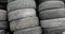 Stacks of used rubber car tires at processing recycling plant, camera in motion.