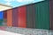 Stacks of various colorful metal fence panels and metal roof sheets for sale. Building and construction materials, colored steel