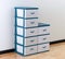 Stacks of white and blue plastic drawers