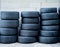 Stacks of worn radial car tires outside a mechanic