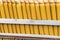 Stacks of yellow ceramic glazed curved roof tiles in a symmetrical pattern