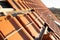 Stacks of yellow ceramic roofing tiles for covering residential building roof under construction