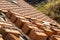 Stacks of yellow ceramic roofing tiles for covering residential building roof under construction