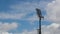 Stadium floodlight against blue sky with white clouds