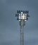 Stadium floodlight lamp post against blue evening sky