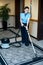 Staff cleaning carpet with a vacuum cleaner
