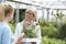 Staff Giving Plant Advice To Female Customer At Garden Center