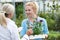 Staff Giving Plant Advice To Female Customer At Garden Center