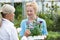 Staff Giving Plant Advice To Female Customer At Garden Center