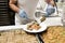 Staff in gloves putting Turkish baklava on a plate for a guest at all-inclusive hotel. Delicious traditional sweets on a plate.