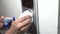staff hand using wet wipe cleaning an elevator push button control panel