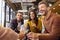 Staff At Informal Meeting In Office With Takeaway Pizza And Drinks