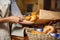 Staff packing bread in paper bag at bakery shop