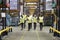 Staff in reflective vests walking to camera in a warehouse