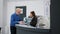 Staff and senior patient filling in report papers at facility reception desk