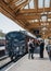 Staff talking on platform next to The Poppy Line steam train, Sheringham, Norfolk, UK