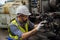 Staff or technicians are checking the operation of the old machine via the remote. Man worker in safety helmet working on steel