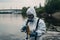Staff wearing white chemical protective mask and radioactive protective suit check water quality from chemical plants or factory