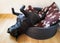 Staffordshire bull terrier dog sleeping in a plastic bed with a brown cushion with his head hanging out onto a hard floor.