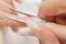 Stage of manicure: nail shaping by tweezers