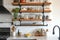 Stage shelves in a kitchen featuring minimalist black metal pipe brackets that are one rod and feature a circular base on the wall