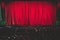 Stage with velvet red curtain in theater cinema, empty old-fashioned elegant theatre wooden stage with red cloth drapes curtains