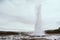 Stages of the eruption of the famous Strokkur Geyser In Iceland on a cold cloudy afternoon. Giant blue bubble right before the