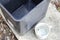 Stagnan water in rubbish container and plastic cup potentially for musquitoes breeding ground. Blurred image