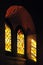 Stained colored glass gothic window with reflection on wall