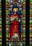 Stained glass window depiction of Jesus holding cross bearing orb.