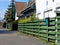 Stained green wooden fence and white facade