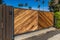Stained natural wood modern and clean wood driveway property private gate entrance in a tropical location with secure