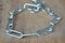 Stainless dog choke chain collar on wooden board