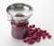 A stainless funnel filling a jar of preserves with raspberry jam